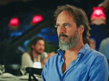 a man with a beard in a blue shirt