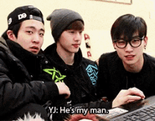 a group of young men are looking at a computer screen and one of them is saying yj he 's my man