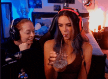 a woman wearing headphones is holding a glass with a straw