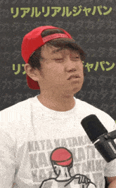a man wearing a kata kataka t-shirt with a microphone