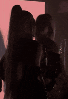 a pixelated image of two women hugging each other in front of a green background