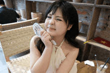 a woman looks at her face in a mirror while sitting in a chair