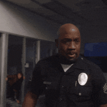 a man in a police uniform has a badge that says ' los angeles police department ' on it