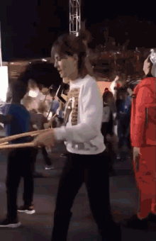 a woman in a white shirt with the word ' snoop dogg ' on it is walking in a crowd