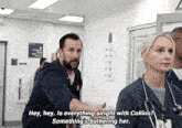 a man and a woman are talking in a hospital hallway and the man is saying " hey hey is everything alright with collins "