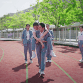 a girl is carrying another girl on her shoulders on a track with a watermark that says linsoongirls