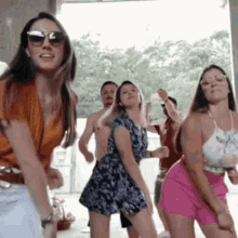 a group of women are dancing together in front of a man .