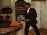 a man in a suit and tie is standing in a living room