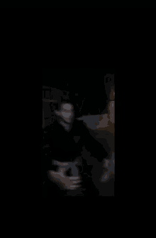 a blurry picture of a man in a mask in a dark room .