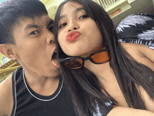 a boy and a girl are posing for a picture and the girl has red lips