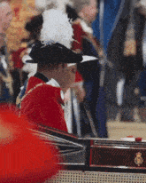 a man wearing a hat with feathers is sitting in a car