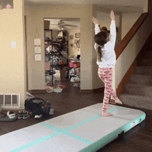 a little girl stands on a mat in a living room