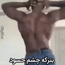 a man without a shirt is standing with his hands behind his head and a foreign language written below him