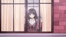 a girl is looking out of a window .
