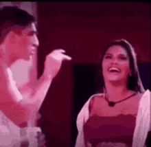 a man and a woman are laughing and talking to each other in a dark room .