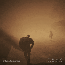 a poster for dune awakening shows a man walking in a foggy area