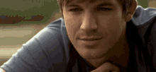 a close up of a man 's face with a hand on his chin