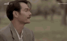 a man in a suit with his hand on his chin