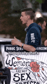 a man holding a sign that says women are not sex objects