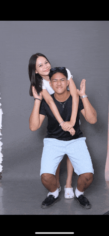 a man is carrying a girl on his shoulders and they are posing for a picture