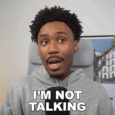 a man in a gray hoodie says " i 'm not talking "