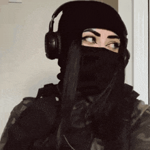 a woman wearing a black mask and headphones .