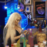 a woman is sitting at a table with bottles and a sign that says " are "