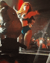 a woman in a bikini is dancing on a stage