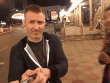 a man is holding a pen in front of a sign that says no smoking