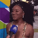 a woman is talking into a microphone while wearing a carnival costume .