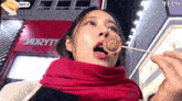 a woman eating a skewer in front of a mix2ytt building