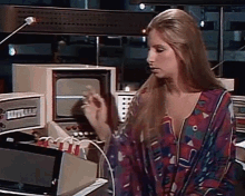 a woman in a colorful shirt is standing in front of a machine that says ' a ' on the front of it