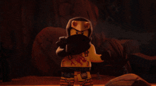 a lego figure with a scarf around his neck has a tattoo on his chest that says ' ninjago '
