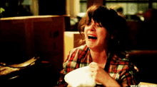 a woman in a plaid shirt is crying while holding a napkin in her hand