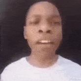 a close up of a person 's face with a white shirt on against a black background .