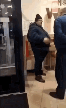 a man in a blue jacket is standing in a burger king restaurant