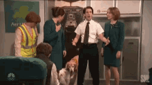 a group of people are standing around a man with a dog in front of a sign that says aerl
