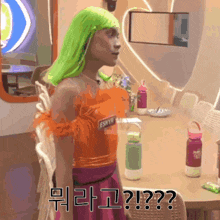 a woman in a green wig is standing in front of a table with bottles on it