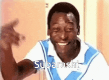 a man in a blue and white shirt is smiling and says subarashi on the bottom