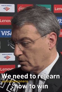 a man wearing glasses and a suit with the words " we need to relearn how to win " on the bottom