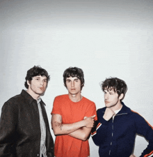 three men standing next to each other with their arms crossed and one has a tattoo on his arm
