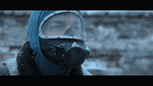 a man wearing a gas mask and goggles looks at something