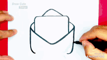 a person is drawing an envelope with a pen on a piece of paper ..