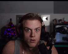a man wearing headphones and a microphone looks at the camera