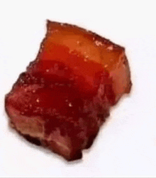 a piece of red meat is on a white plate .