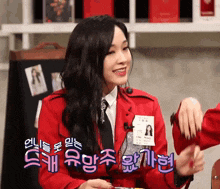 a woman in a red jacket has a name tag on her chest that says ' eun ' on it