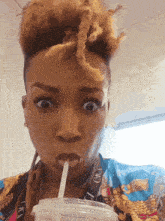 a woman drinking through a straw with a lanyard that says ' gkc ' on it
