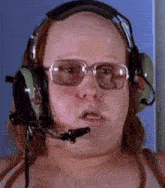 a close up of a bald man wearing headphones and glasses .