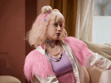a woman with pink hair is wearing a pink fur coat