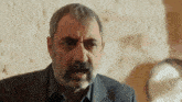a man with a beard and mustache is making a funny face while wearing a suit .